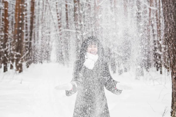 女の子は公園で雪と遊ぶ — ストック写真