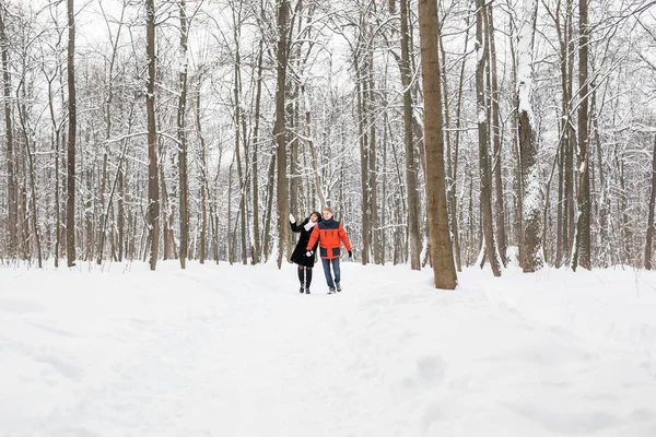 Jeune couple amoureux se tenant la main en plein air en hiver — Photo