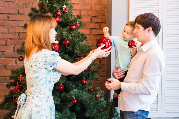 Koncepcja rodziny, Boże Narodzenie, x-mas, zima, szczęścia i osób - uśmiecha się rodziny dekorowanie choinki — Zdjęcie stockowe