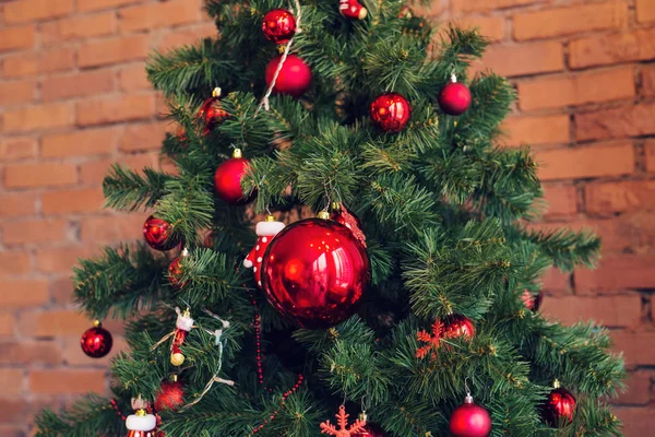 Closeup de bugiganga vermelha pendurada em uma árvore de Natal decorada . — Fotografia de Stock