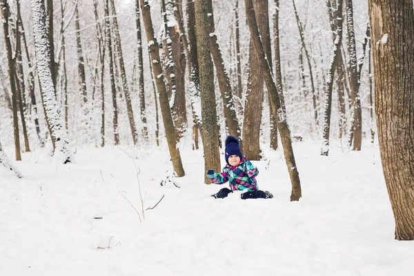 Menina criança feliz jogando em um belo parque de inverno nevado no dia de Natal — Fotografia de Stock