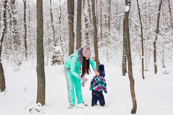 Mãe e criança brincando com neve ao ar livre — Fotografia de Stock