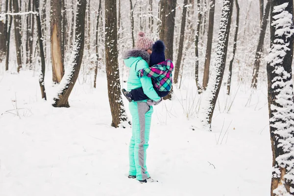 Família feliz mãe e criança bebê filha em um passeio de inverno na floresta — Fotografia de Stock