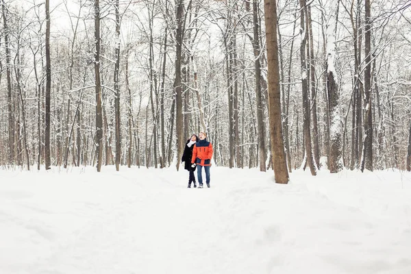 Amor, relacionamento, temporada, amizade e conceito de pessoas homem e mulher andando na floresta de inverno — Fotografia de Stock