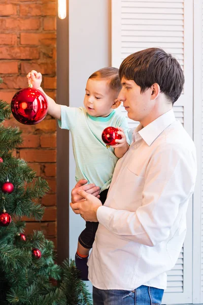 Syn i ojciec dekorowanie choinki w domu w salonie — Zdjęcie stockowe