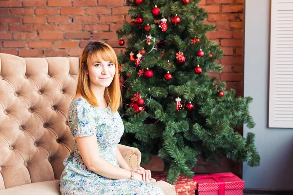 Vacaciones, x-mas, invierno, concepto de felicidad - mujer sonriente cerca del árbol de Navidad —  Fotos de Stock