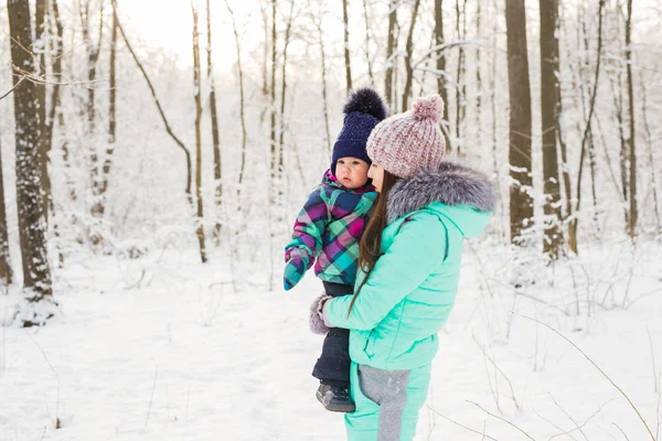 Young brunette mother with her daughter outdoors. Winter time — Stock Photo, Image