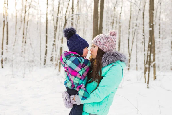 Young brunette mother with her daughter outdoors. Winter time — Stock Photo, Image