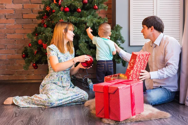 Feliz familia decorando el árbol de Navidad juntos. Padre, madre e hijo. Lindo niño. Niño. — Foto de Stock