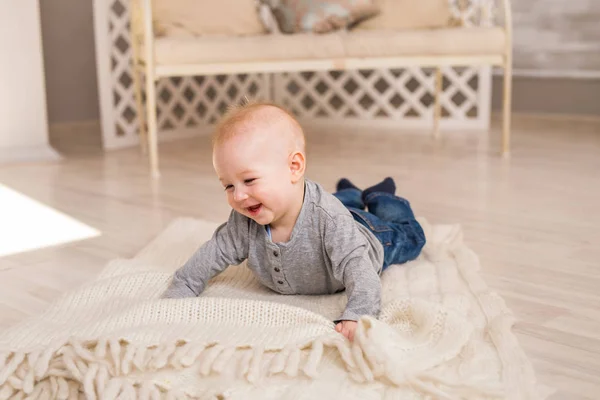 可爱爱笑的宝贝男孩在白色阳光明媚的卧室里。刚出生的孩子放松。家庭早上在家. — 图库照片