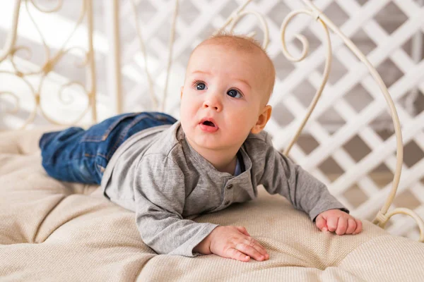 Adorable bebé en el dormitorio blanco y soleado. Niño recién nacido relajándose. Mañana familiar en casa . — Foto de Stock