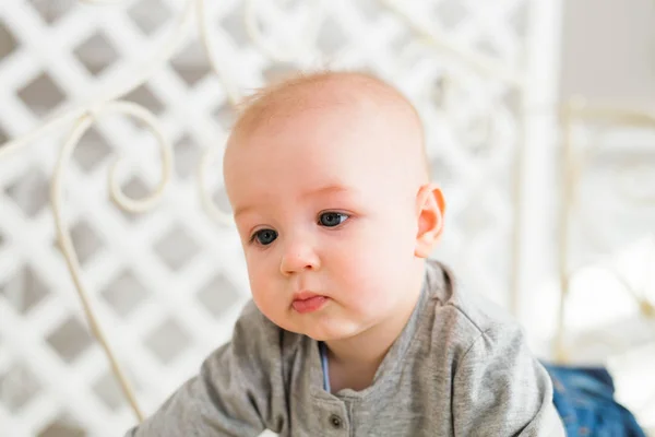 Menino adorável no quarto ensolarado branco. Recém-nascido relaxante. Manhã de família em casa . — Fotografia de Stock