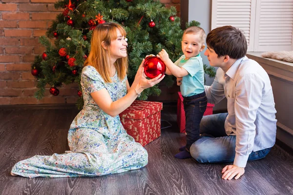 Família feliz jogando com bolas de Natal em casa — Fotografia de Stock