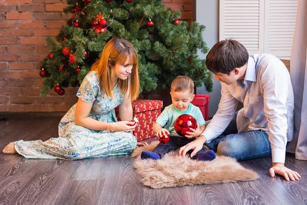 Familia feliz jugando con bolas de Navidad en casa — Foto de Stock