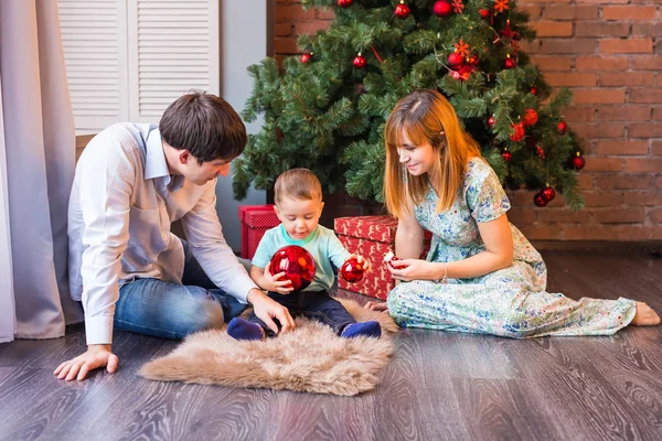 Familia feliz jugando con bolas de Navidad en casa — Foto de Stock