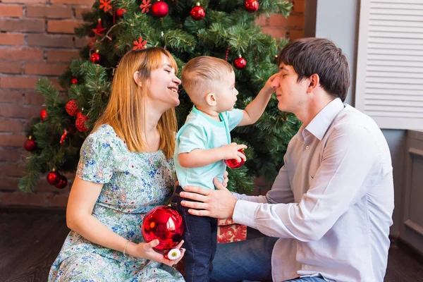 Familia feliz jugando con bolas de Navidad en casa — Foto de Stock