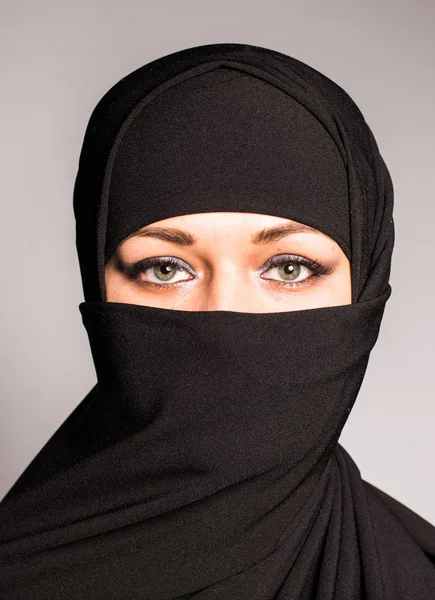 Portret van een jonge Arabische vrouw met haar mooie blauwe ogen in traditionele islamitische doek niqab. — Stockfoto