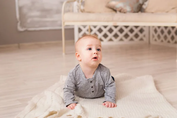 Adorable niño risueño en el dormitorio blanco y soleado. Niño recién nacido relajándose. Mañana familiar en casa . —  Fotos de Stock