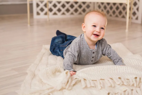 Adorable niño risueño en el dormitorio blanco y soleado. Niño recién nacido relajándose. Mañana familiar en casa . — Foto de Stock