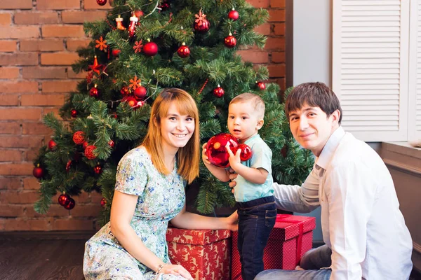 Счастливая семья играет с рождественскими шарами дома — стоковое фото