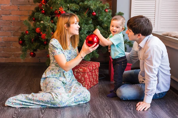 Familia feliz jugando con bolas de Navidad en casa — Foto de Stock