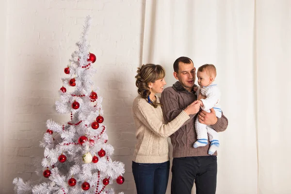Feliz familia sonriente cerca del árbol de Navidad — Foto de Stock