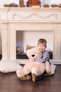 Noel ağacının altında yumuşak oyuncak ayı ile oynayan çocuk çocuk.