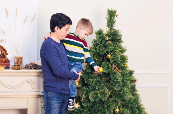 Pai e filho estão decorando a árvore de Natal — Fotografia de Stock