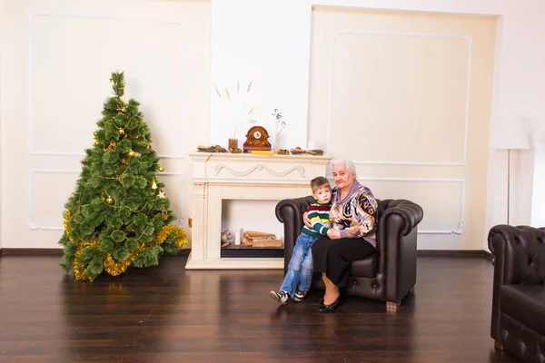 Nieto y abuela cerca del árbol de Navidad —  Fotos de Stock