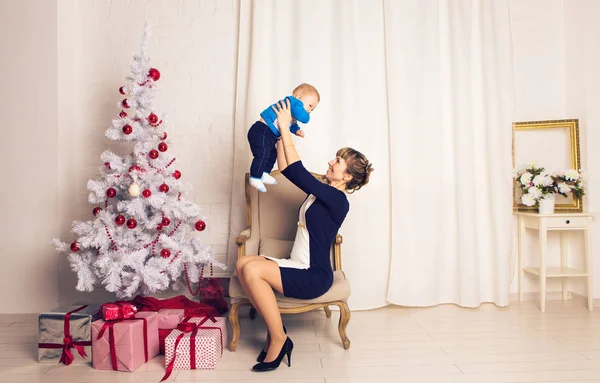 Ευτυχισμένη οικογένεια μητέρα και το μωρό ο μικρός γιος παίζει σπίτι στις διακοπές των Χριστουγέννων. Νέα χρόνια διακοπές. Νήπια με τη μαμά στην αίθουσα γιορταστικά διακόσμησα με Χριστουγεννιάτικο δέντρο. Πορτρέτο του μητέρα και μωρό αγόρι — Φωτογραφία Αρχείου
