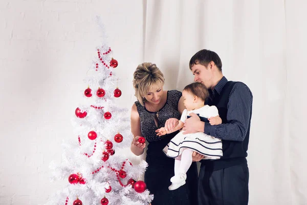 Feliz Natal e Boas Festas. Pais e bebê menina se divertindo e brincando juntos perto da árvore de Natal dentro de casa . — Fotografia de Stock