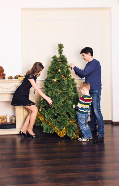 Família, x-mas, férias de inverno e conceito de pessoas - mãe, pai e criança decorando árvore de Natal em casa — Fotografia de Stock