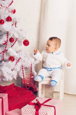 Noel ağacının yanında oynayan neşeli küçük oğlu