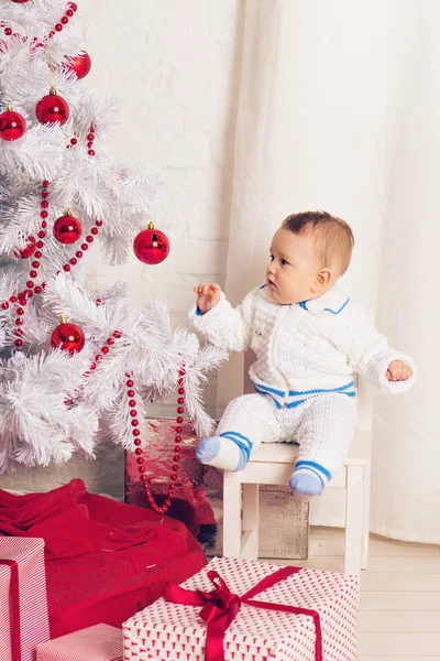 Cheerful little baby boy playing near the Christmas tree — Stock Photo, Image