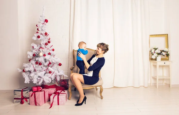 Ευτυχισμένη οικογένεια μητέρα και το μωρό ο μικρός γιος παίζει σπίτι στις διακοπές των Χριστουγέννων. Νέα χρόνια διακοπές. Νήπια με τη μαμά στην αίθουσα γιορταστικά διακόσμησα με Χριστουγεννιάτικο δέντρο. Πορτρέτο του μητέρα και μωρό αγόρι — Φωτογραφία Αρχείου