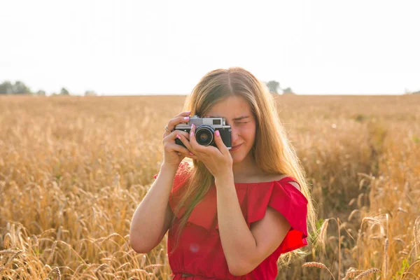 Fotógrafa femenina en el campo con una cámara tomando fotos — Foto de Stock