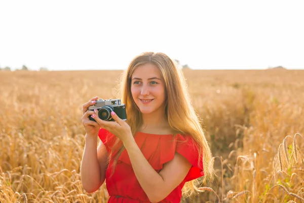 Vrouwelijke fotograaf in het veld met een camera fotograferen — Stockfoto