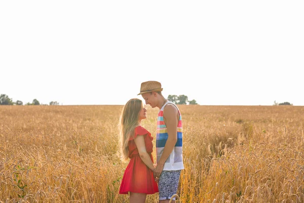 Romantic couple holding hands in the field — Stock Photo, Image