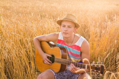 Mutlu yakışıklı adam alanında gitar çalıyor