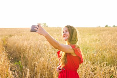 Sarı alan doğa arka plan ile selfie fotoğrafını alarak güzel bir kadın. Çekici bir genç gülümseyen kız portresi kapatın. Eğlenceli kavramı