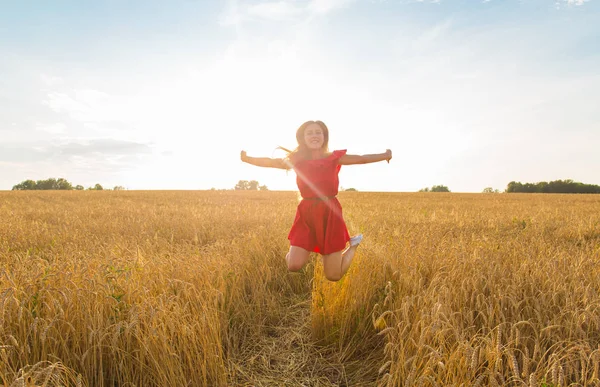Güzellik kız açık havada zevk doğa. Yaz veya sonbahar alan atlama Kırmızı elbiseli güzel genç Model kız... Özgür mutlu kadın. — Stok fotoğraf