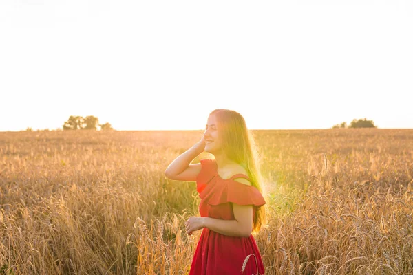 Mädchen im roten Kleid auf dem Feld. — Stockfoto