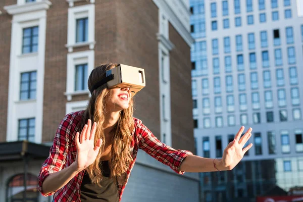 Beautiful young woman wearing virtual reality headset in an urban context — Stock Photo, Image