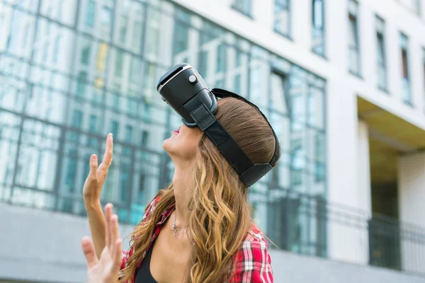 Young woman using high tech virtual reality glasses outdoor