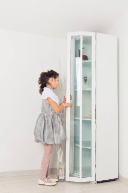 Sevimli küçük kız bir oyuncak ayı sarılma. Şirin Bebek evde beyaz odada.