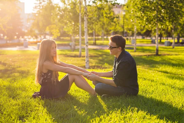 Пара в парке, сидящая на траве, хорошо проводим время вместе. — стоковое фото