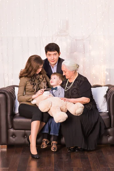 Concept de famille, bonheur, génération et personnes - famille heureuse assise sur le canapé à la maison — Photo