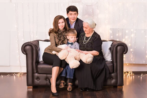 Familia, felicidad, generación y concepto de personas - familia feliz sentado en el sofá en casa —  Fotos de Stock