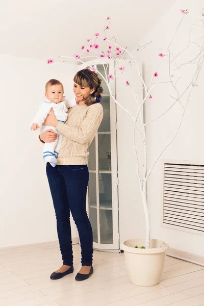 Madre y su hijo, abrazándose con ternura y cuidado, dando flores a la madre. Concepto del Día de la Madre, felicidad y amor — Foto de Stock