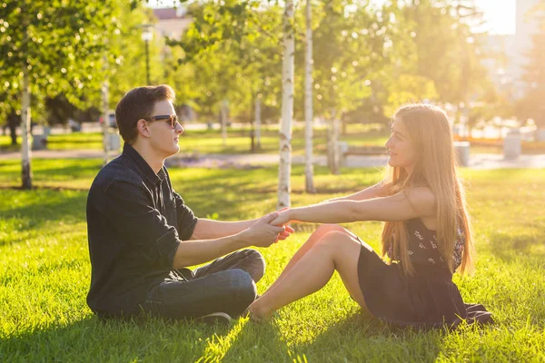 Пара в парке, сидящая на траве, хорошо проводим время вместе. — стоковое фото